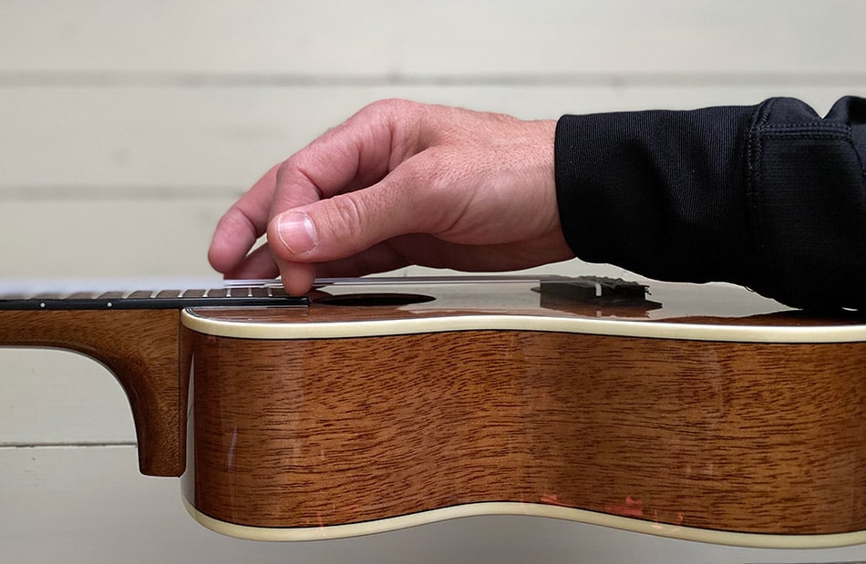 Strumming ukulele with index finger close up